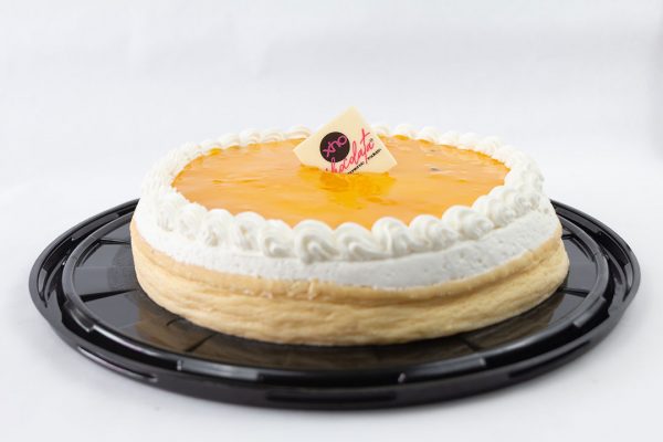 Cremoso Cheesecake cubierto con crema batida y mermelada de Mango